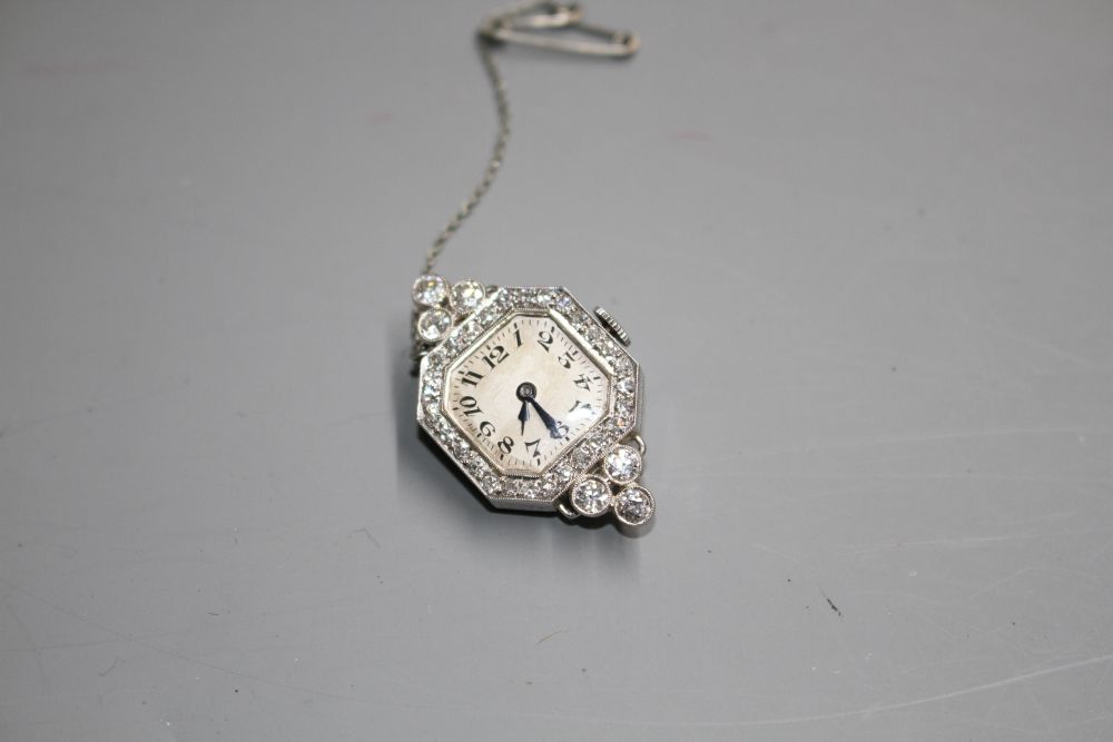 A ladys platinum and diamond set manual wind wrist watch (no strap) now with brooch fitting, 33mm.